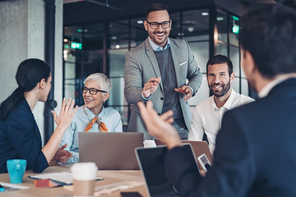 An image of a business meeting with people smiling.