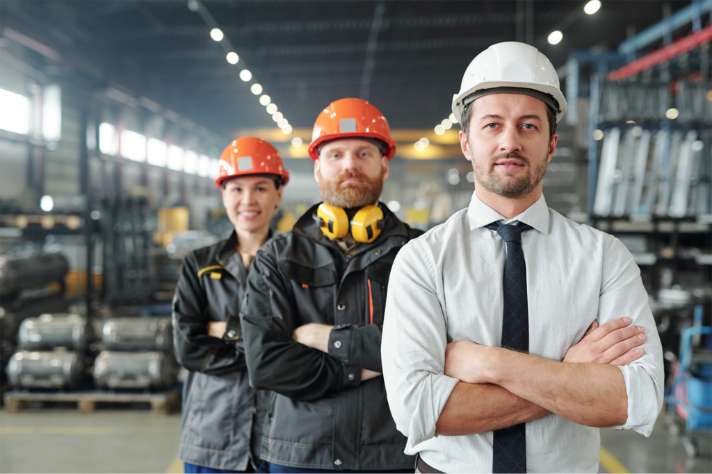Three manufacturing workers standing with arms crossed looking confident.