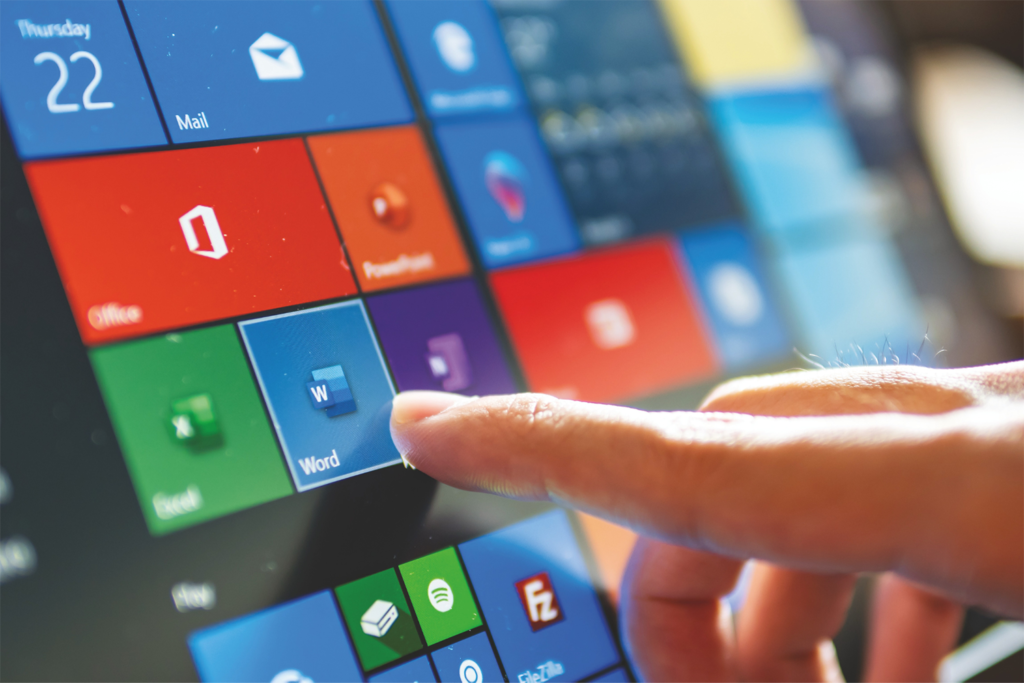 A finger pointing at microsoft word on the screen.