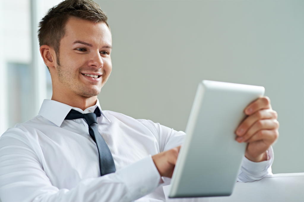 Man in shirt and tie using a tablet.