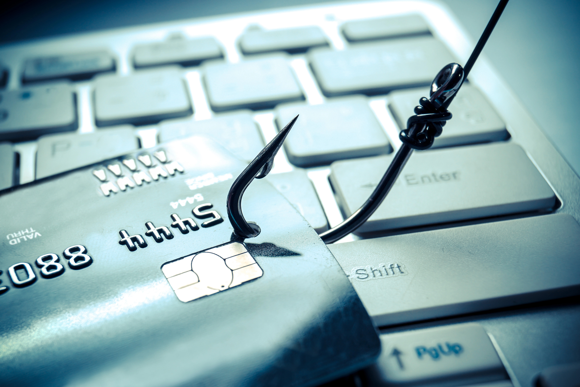 A keyboard with a hook attached to a credit card to emulate a phishing attack.