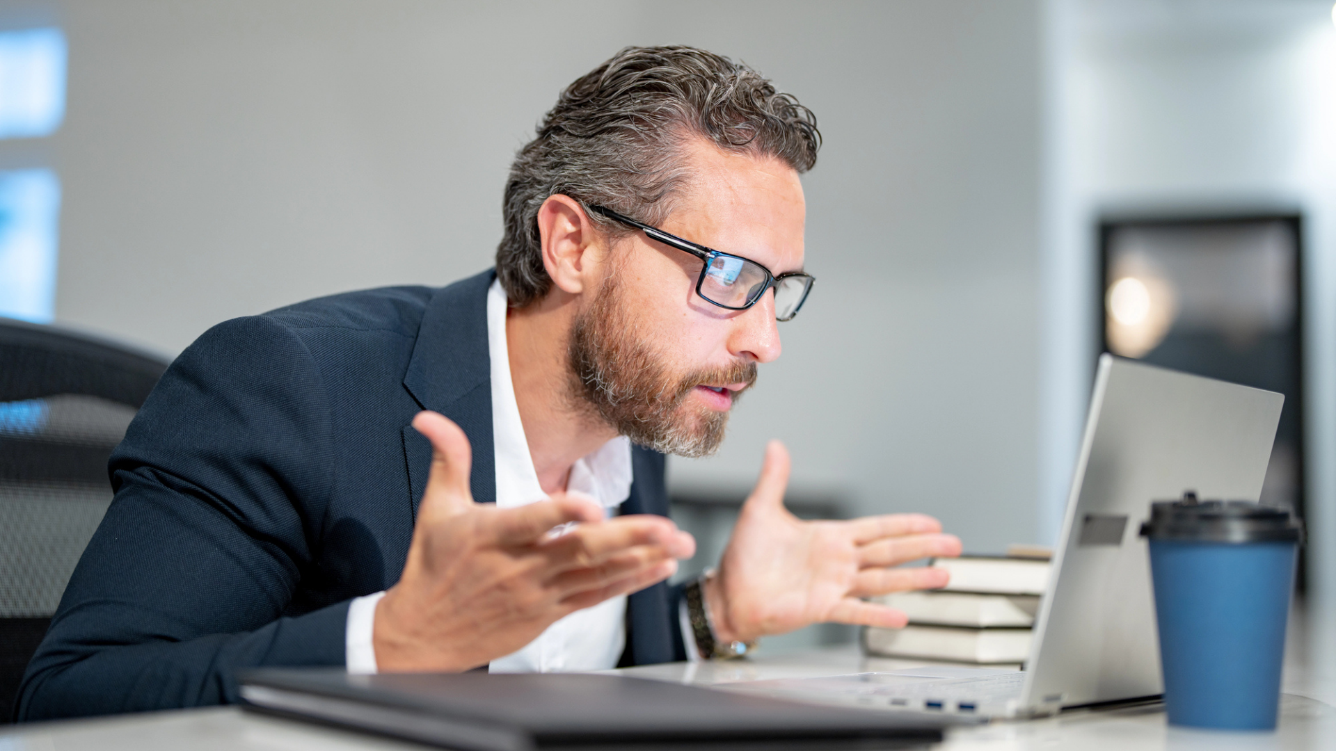 A man on a laptop worried about what he is seeing on the screen.